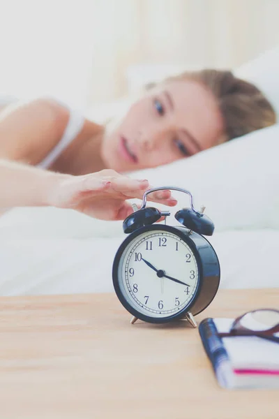 Young sleeping woman and alarm clock in bedroom at home. Young sleeping woman.