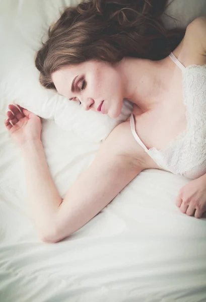 Pretty woman lying down on her bed at home. — Stock Photo, Image