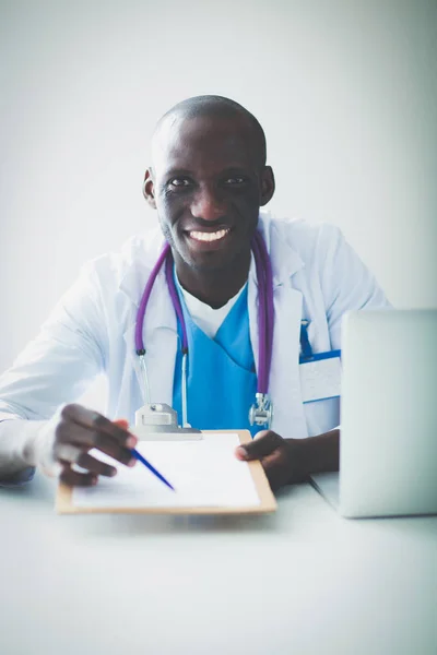 Porträtt av ung manlig läkare bär headset när du använder datorn vid skrivbordet på kliniken. Läkare. — Stockfoto