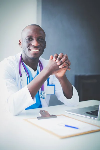 Retrato de jovem médico vestindo fone de ouvido ao usar o computador na mesa na clínica. Doutor.... — Fotografia de Stock