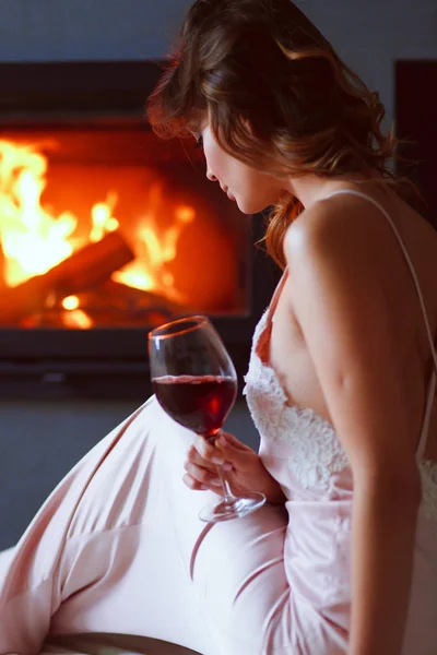 Mujer sexy frente a la chimenea. Chimenea de madera . —  Fotos de Stock