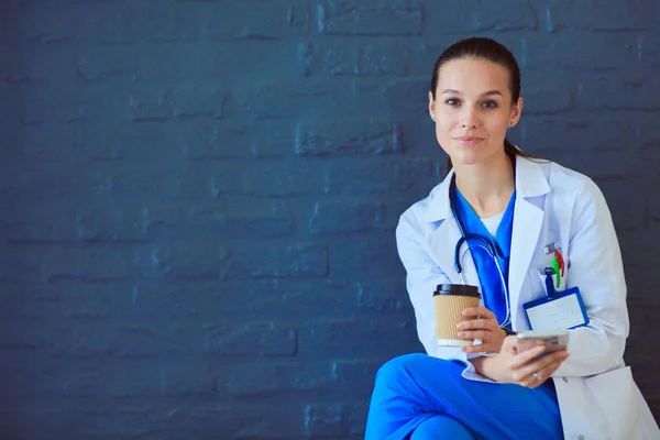 Young woman doctor sitting with your phone. Woman doctors. — Stock Photo, Image