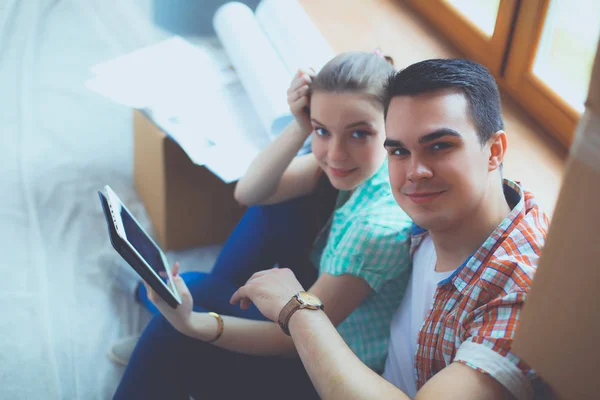 Casal movendo-se em casa sentado no chão com ipad. Casal. — Fotografia de Stock