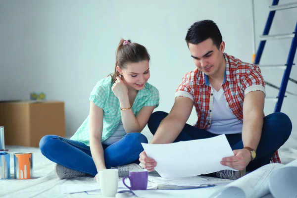 Casal jovem sentado no chão e calculando sobre eles economia. Casal jovem — Fotografia de Stock