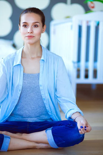 Mujer joven haciendo yoga en casa en la posición de loto. Mujer joven haciendo yoga . — Foto de Stock