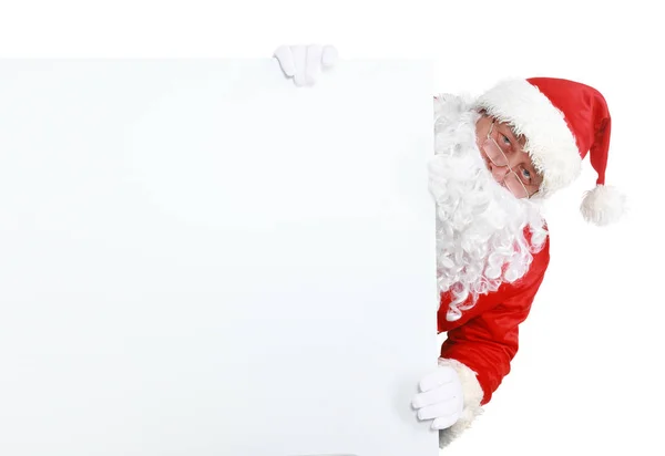 Счастливый Санта-Клаус, выглядывающий из-за таблички на белом фоне — стоковое фото