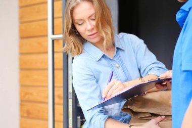 Mavi üniformalı gülümseyen kurye servis konseptine paket kutusu teslim eden teslimatçı. Mavi üniformalı gülümseyen teslimatçı.