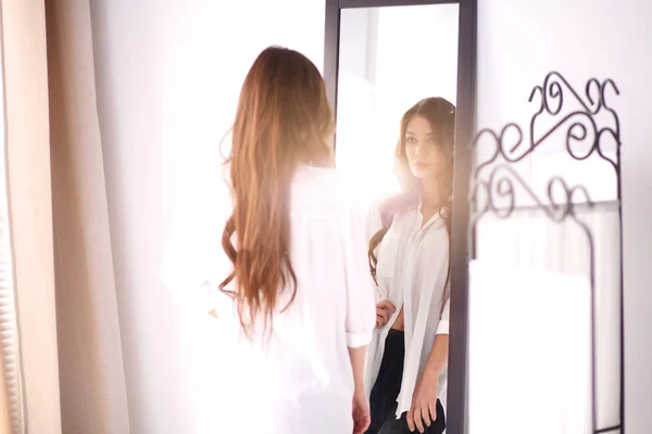 젊은 여자는 집에서 거울에 반사 자신을 보고. 젊은 여자. — 스톡 사진