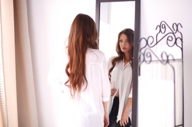 Genç kadın kendini yansıma evde aynaya bakıyorum. Genç kadın.