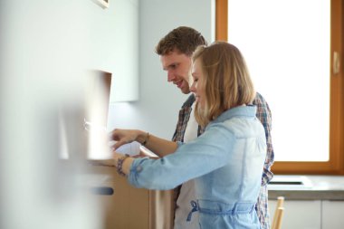 Genç bir çift yeni evde büyük karton kutu taşıyan. Ev taşıma. Genç Çift