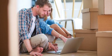 Genç bir çift yeni ev içinde hareket. Katta oturan ve açma sonra rahatlatıcı. Bir şey üstünde laptop arıyorum