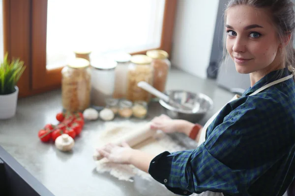 Belle femme cuisine gâteau dans la cuisine debout près du bureau. — Photo