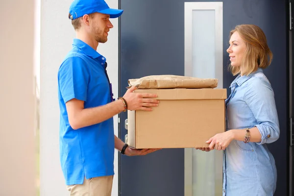 Livreur souriant en uniforme bleu livrant la boîte de colis au destinataire concept de service de messagerie. Livreur souriant en uniforme bleu — Photo