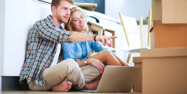 Genç bir çift yeni ev içinde hareket. Katta oturan ve açma sonra rahatlatıcı. Bir şey üstünde laptop arıyorum