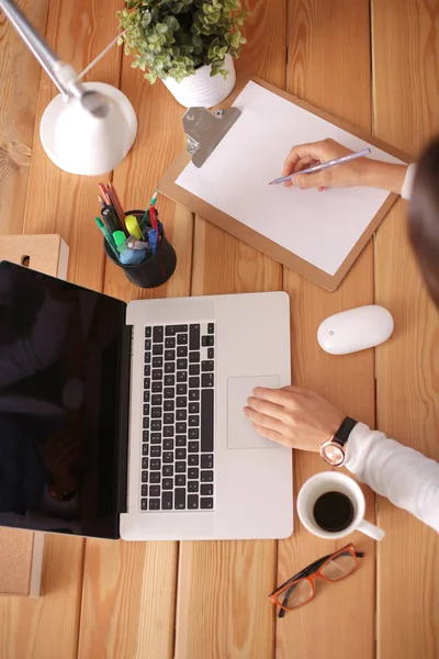 Jonge vrouw werkend zittend aan een bureau. — Stockfoto