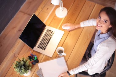 Masasında oturan ve elinde bir fincan kahveyle rahatlamış genç bir kadının portresi. İş kadını. İşyeri