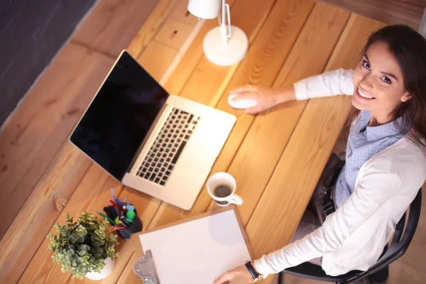 Masasında oturan ve elinde bir fincan kahveyle rahatlamış genç bir kadının portresi. İş kadını. İşyeri