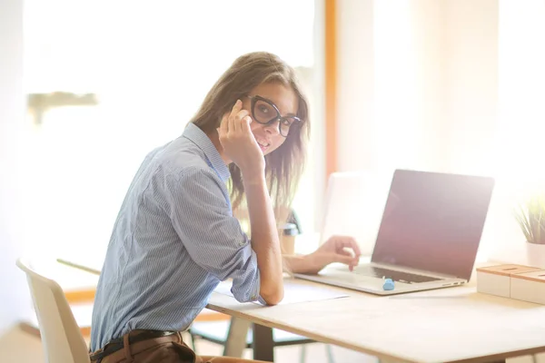 Mujer joven sentada en la mesa de la oficina con portátil. Jovencita. Ordenador portátil — Foto de Stock