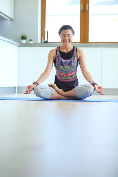 Mujer joven haciendo yoga en casa en la posición de loto. Yoga. Una mujer. Estilo de vida — Foto de Stock