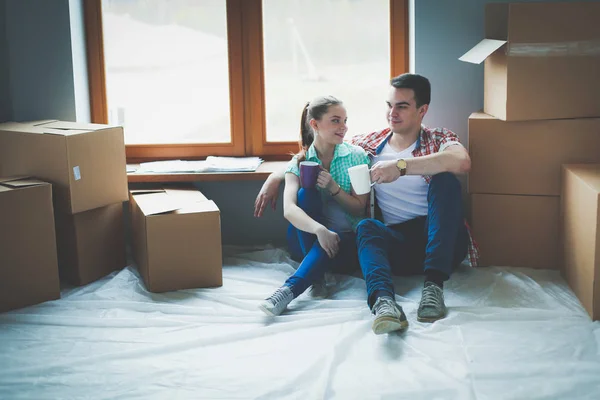 Par som flyttar i huset sitter på golvet. Par — Stockfoto