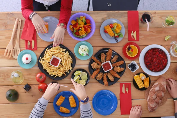 İnsanlar içecekler yemek masasında otururken. Masaya yiyecek. Masaya yiyecek. İnsanlar hızlı yemek yemek.