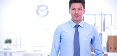 Ofiste masasının karşısında duran bir iş adamı ya da yönetici.