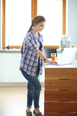 Güzel, genç, gülümseyen bayan doktor masada oturuyor ve yazıyor..