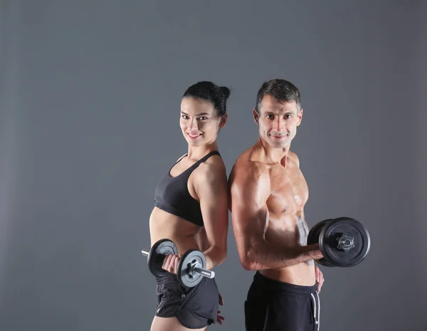 Hombre y mujer atléticos con mancuernas. Instructor de fitness personal. Formación personal . — Foto de Stock