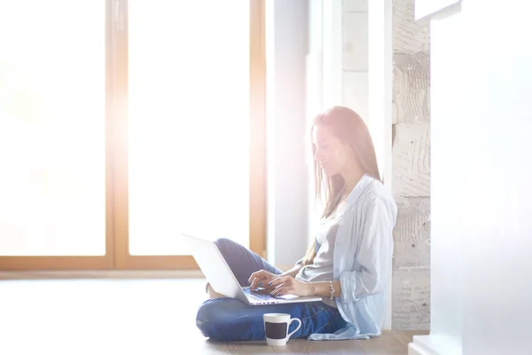 Jovem mulher bonita em casa sentado no chão com laptop. Jovem mulher bonita . — Fotografia de Stock