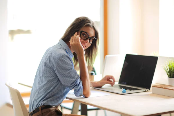 Ung kvinna som sitter vid kontorsbordet med laptop. Ung kvinna. Laptop — Stockfoto