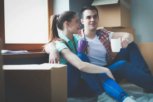 Paar zieht im Haus auf dem Fußboden sitzend ein. Paar — Stockfoto