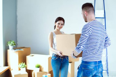 Açma veya kutu ambalaj ve yeni evine taşıdıktan mutlu genç bir çift. Genç Çift