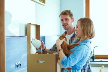 Genç bir çift yeni evde büyük karton kutu taşıyan. Ev taşıma. Genç Çift