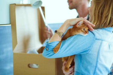 Genç bir çift yeni evde büyük karton kutu taşıyan. Ev taşıma. Genç Çift