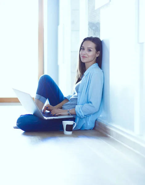 若くてきれいな女性、自宅はノート パソコンで床に座ってください。若くてきれいな女性. — ストック写真