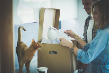 Genç bir çift yeni evde büyük karton kutu taşıyan. Ev taşıma. Genç Çift