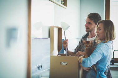 Genç bir çift yeni evde büyük karton kutu taşıyan. Ev taşıma. Genç Çift