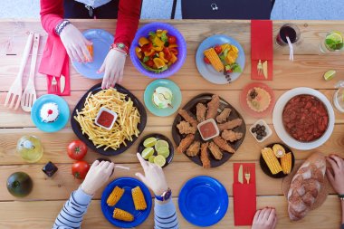 İnsanlar içecekler yemek masasında otururken. Masaya yiyecek. Masaya yiyecek. İnsanlar hızlı yemek yemek.