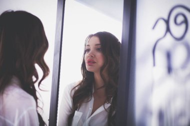 Genç kadın kendini yansıma evde aynaya bakıyorum. Genç kadın.