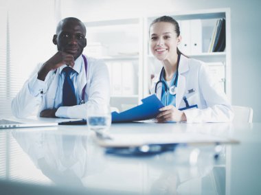 Ofiste tokalaşırken gülümseyen iki genç tıp adamı. Doktorlar. Takım çalışması.