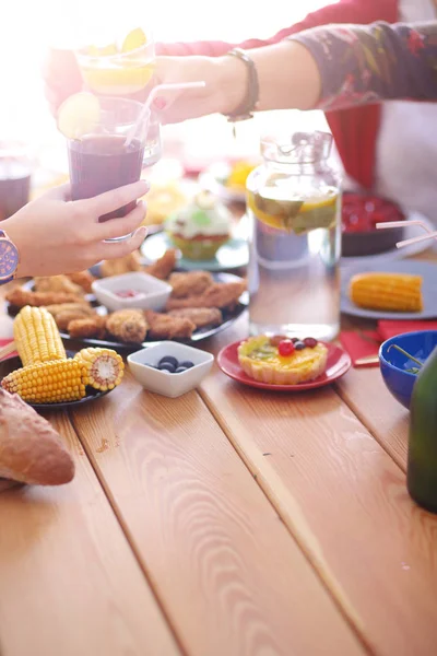 Draufsicht auf eine Gruppe von Menschen beim gemeinsamen Abendessen, während sie am Holztisch sitzen. Essen auf dem Tisch. Menschen essen Fast Food. — Stockfoto