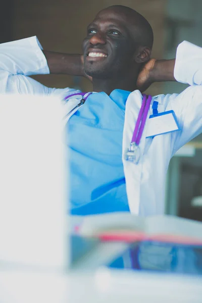 Jeune médecin africain travaillant sur ordinateur portable au bureau. Docteur. Lieu de travail — Photo