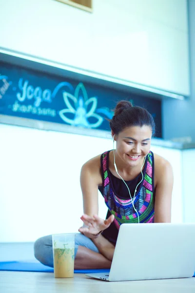 Deportiva mujer sonriente utilizando el ordenador portátil en la habitación luminosa. Una mujer. Estilo de vida — Foto de Stock