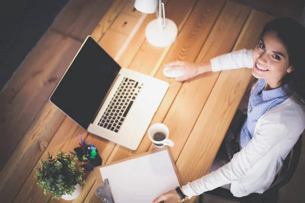 Masasında oturan ve elinde bir fincan kahveyle rahatlamış genç bir kadının portresi. İş kadını. İşyeri