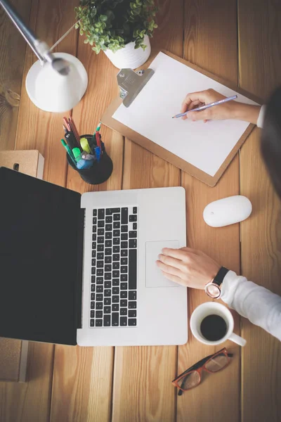 Jonge vrouw werkend zittend aan een bureau. — Stockfoto