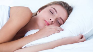 Güzel bir kadın yatağında uzanıyor.