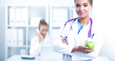 kadın doktor el tutarak ayakta bir yeşil elma