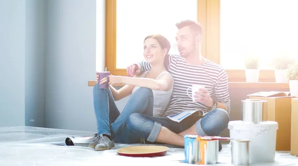 Casal em movimento em casa sentado no chão — Fotografia de Stock