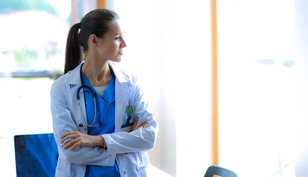 Woman doctor standing at hospital near window — Stock Photo, Image