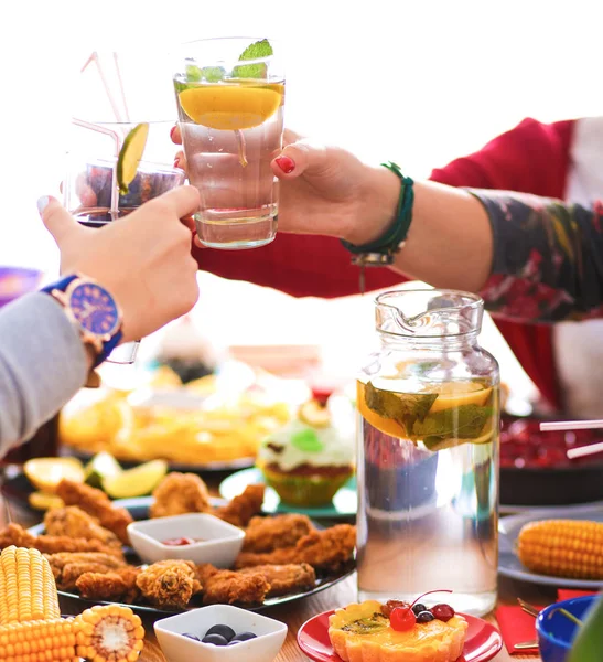 Yemek masasında içki içen insanlar.